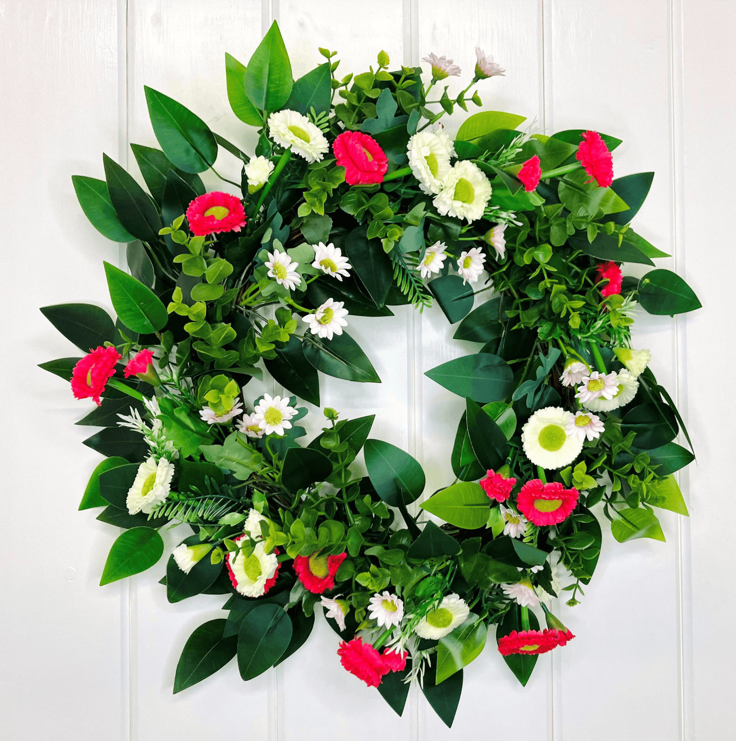 spring summer welcome door wreath with pink and white bellis daisies and greenery