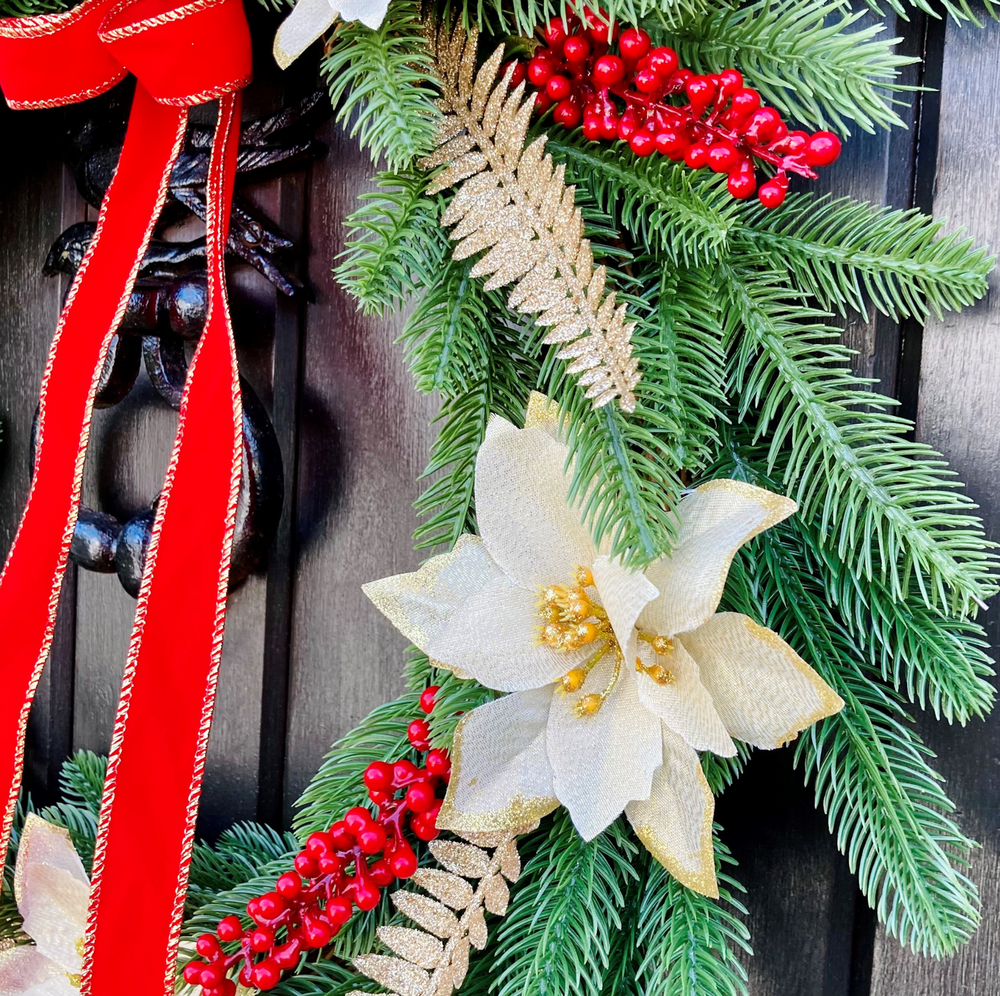 Christmas Wreath With Cream and Gold Poinsettias with Red Berries Presented On A Faux Pine Base