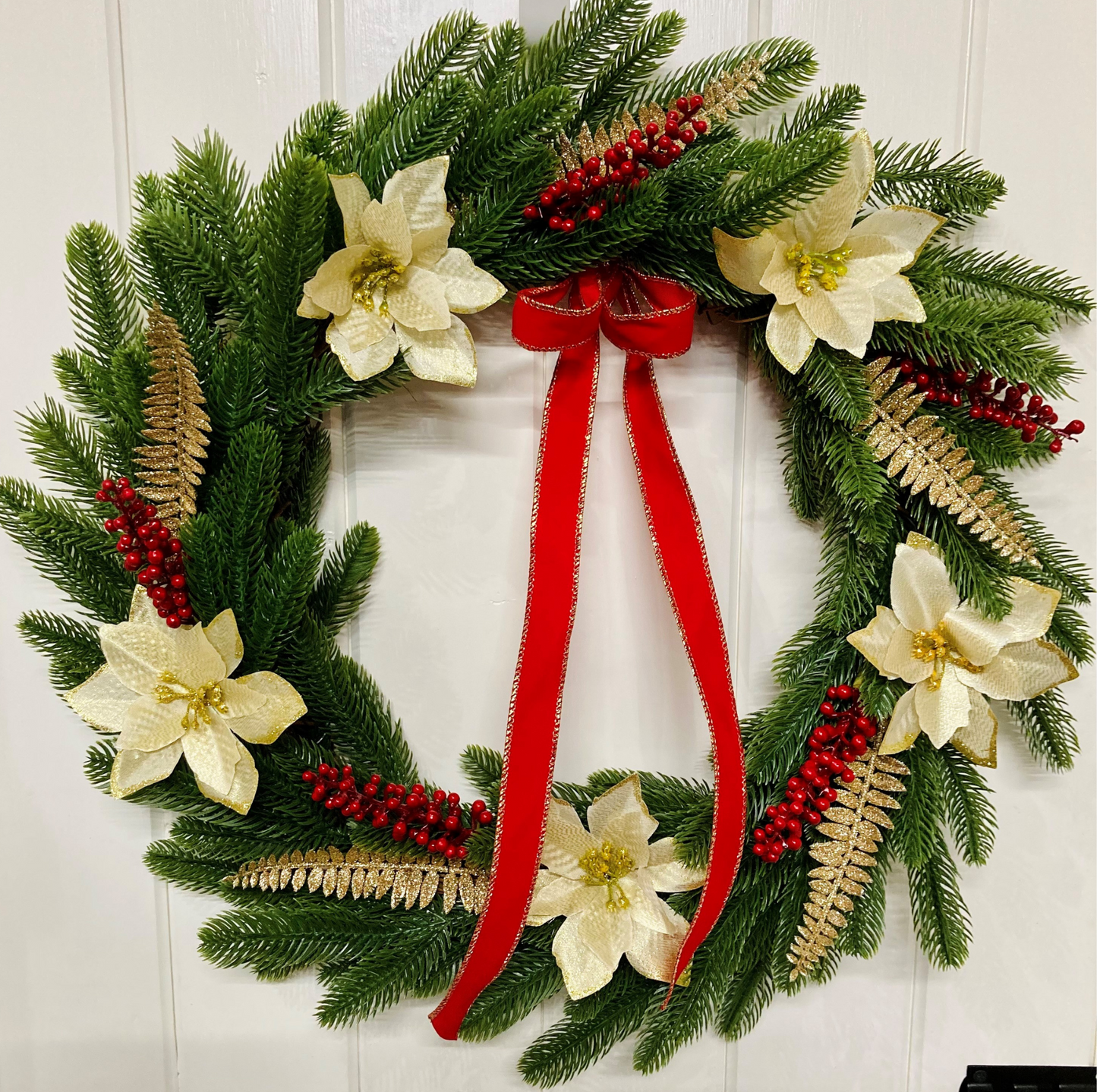 Christmas Wreath With Cream and Gold Poinsettias with Red Berries Presented On A Faux Pine Base