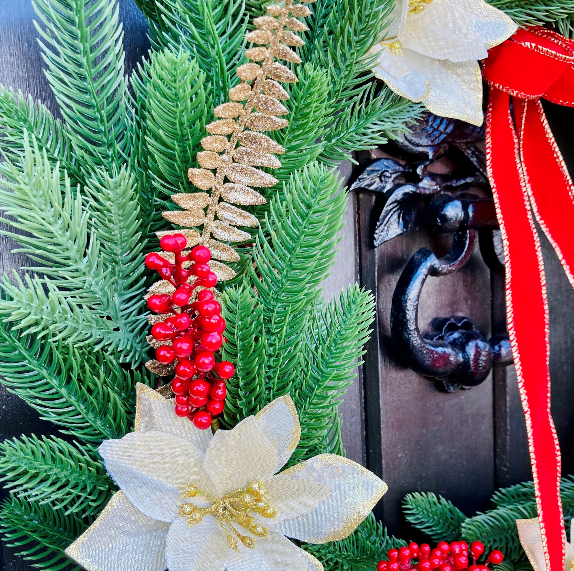 Christmas Wreath With Cream and Gold Poinsettias with Red Berries Presented On A Faux Pine Base