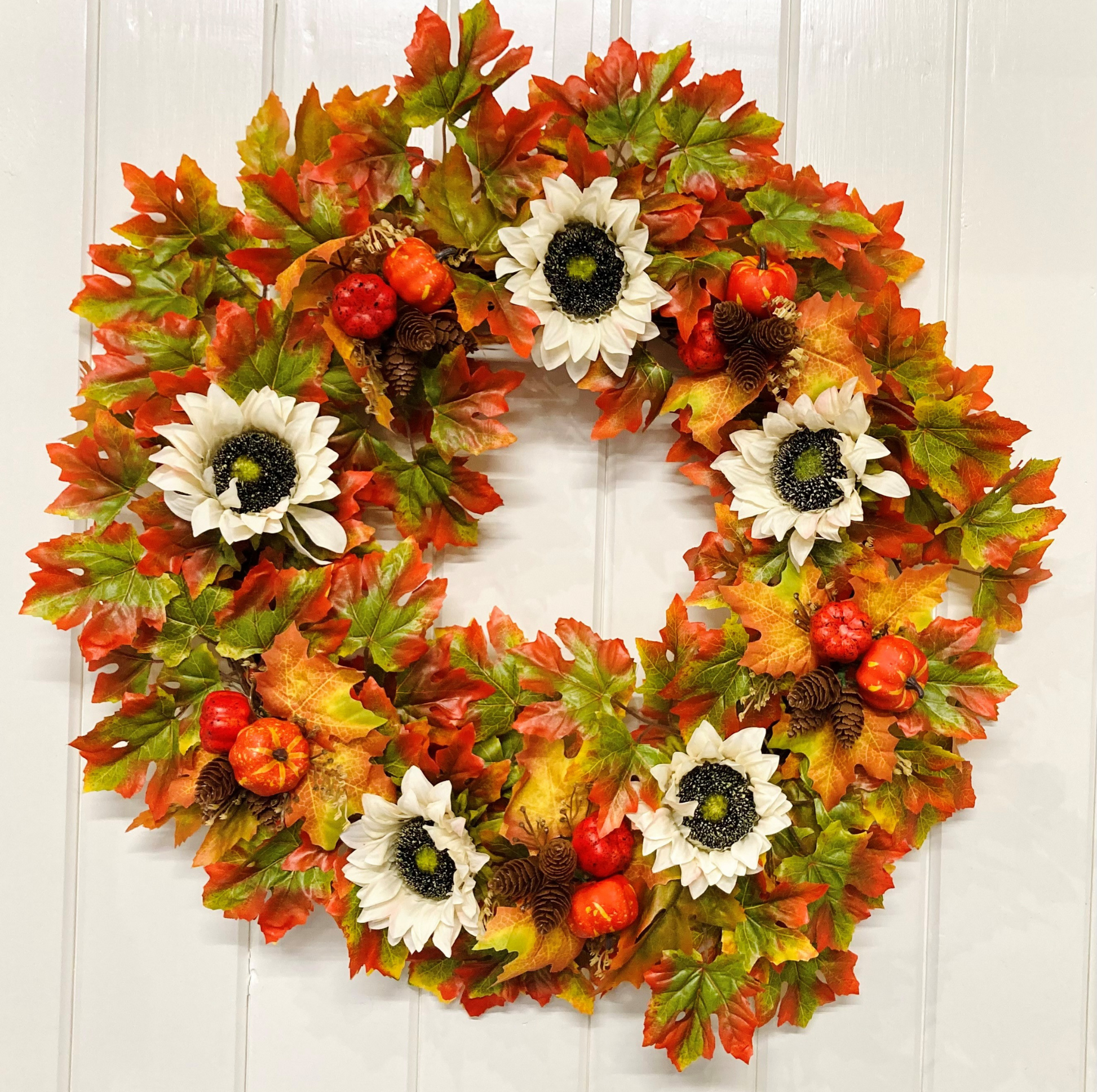 Cream Sunflowers with Pine Cones & Pumpkins set on Autumnal Coloured Crisp Red and Green Maple Leaves on a Grapevine Welcome Door Wreath