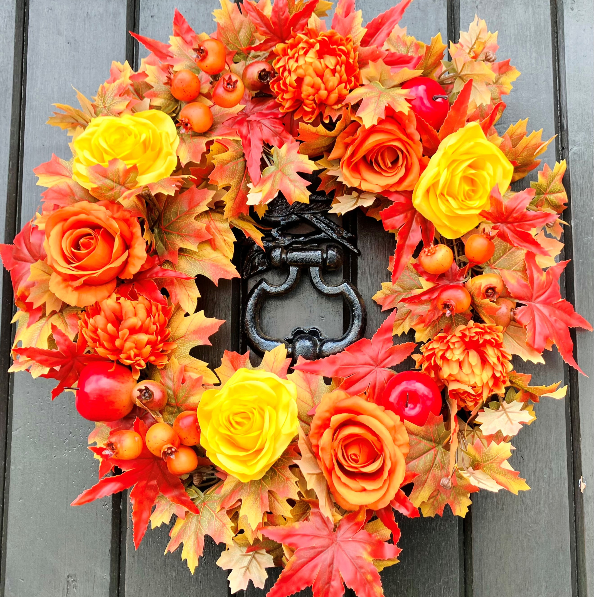 Autumnal coloured Maple leaves, orange Chrysanthemum, yellow Roses with Pomegranates and Red Apples